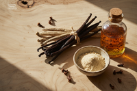 Photo réaliste et premium d’un assortiment de vanille Moon Island : gousses Bourbon noir et TK, poudre de vanille, arôme de vanille avec graines, clous de girofle. Fond clair ou bois exotique, lumière naturelle douce, contraste élevé. Mise en scène élégante et minimaliste, espace pour texte overlay. Image 1200x600 px, style naturel et gourmand, authentique, pas artificielle.
